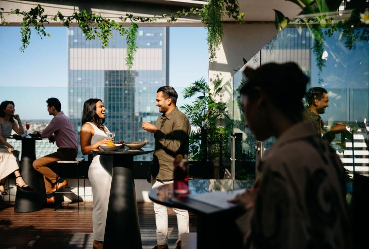 Una coppia che ammira il tramonto al Rooftop at QT, Perth, Western Australia © Tourism Australia 